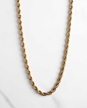 Ett Cordell kedja guld 5mm repkedjehalsband är placerat i en U-form på en vit marmoryta.