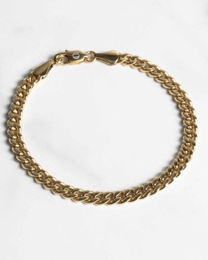 Ett Pansararmband guld 5mm med karbinlås visas i cirkelform på en vit yta.