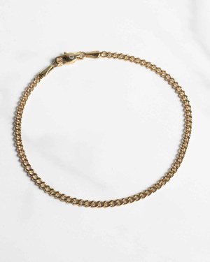 Ett guldigt herrsmycke i form av ett tunt armband i pansarlänk-design